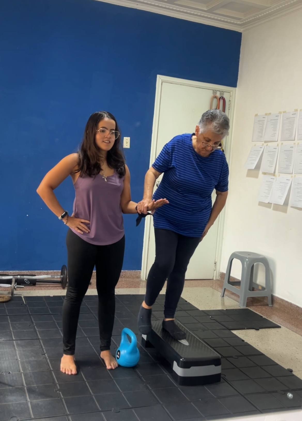 Andrea acompañando a una atleta senior en un ejercicio de equilibrio sobre un step